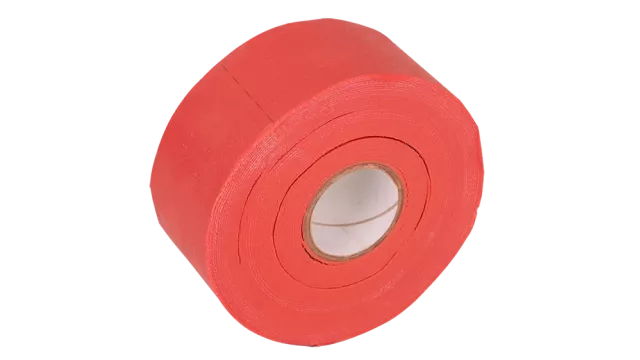A captivating image displays a bold, vibrant red tape roll as its captivating center. The rough, circular texture adds a rugged charm, set against a striking black background. The tapes off-center position, angling towards the top left, highlights its durability and visual presence.