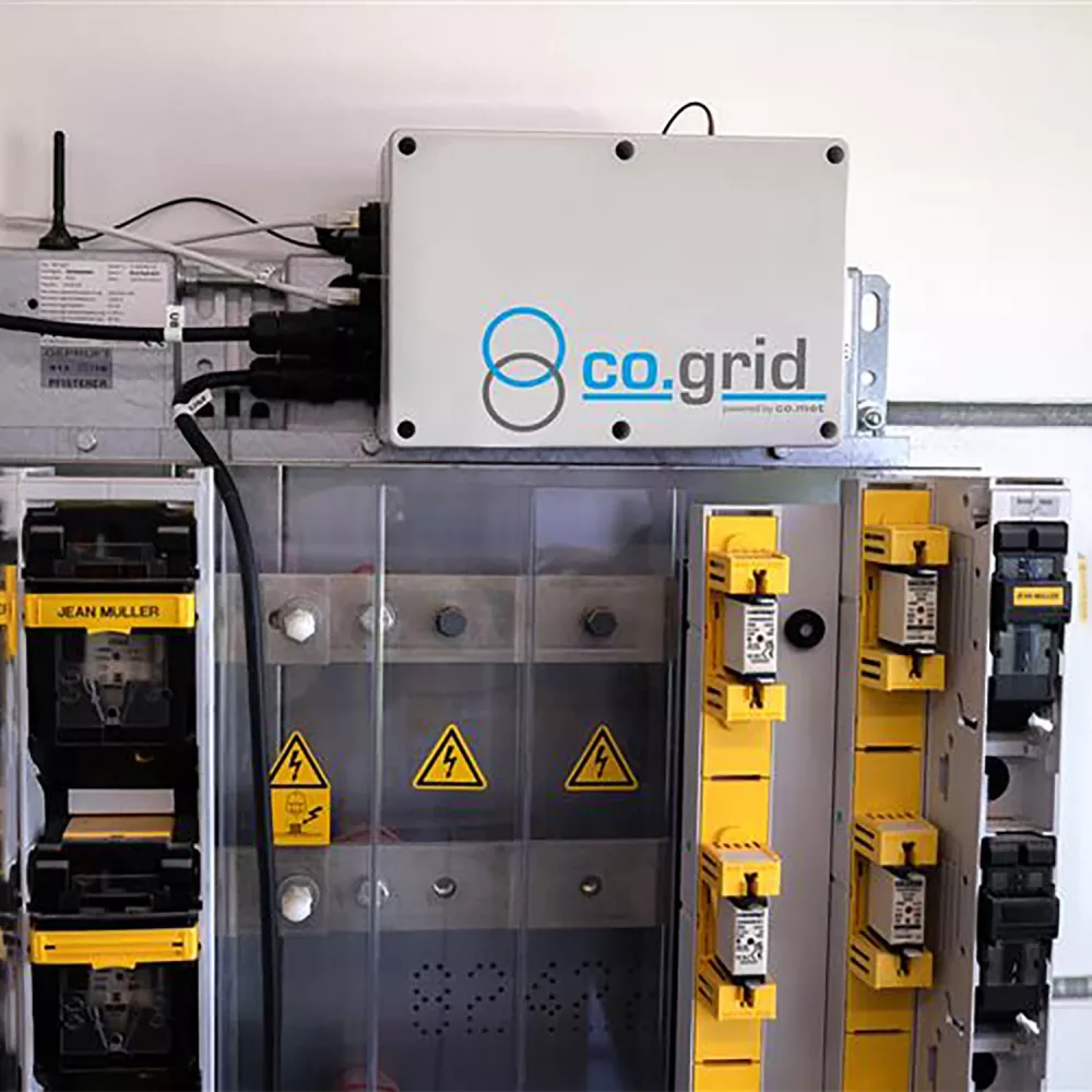 A captivating image displays a detailed close-up of a gray industrial machine, sporting a blue logo. The machines vibrant warning labels, a black-triangle and others, add a professional touch. Set against a pristine white background, it stands out among a backdrop of numerous machines, suggesting a well-organized workspace.